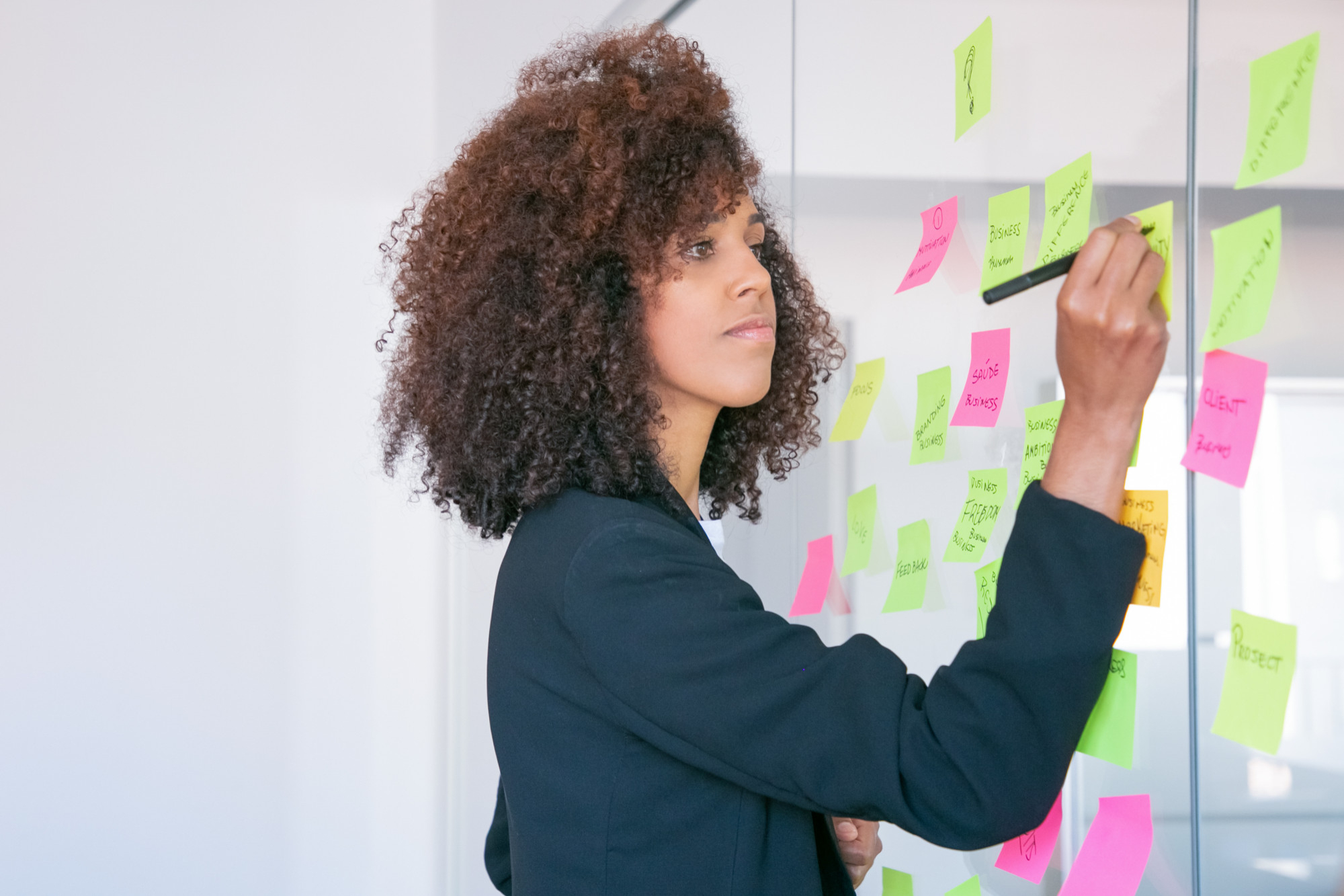 african-american-businesswoman-writing-on-sticker-with-marker-focused-confident-curly-female-manager-sharing-idea-for-project-and-making-note